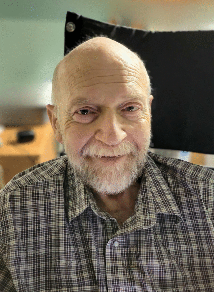 Richard Willowby man smiling with a graying beard and a black & white plaid shirt.
