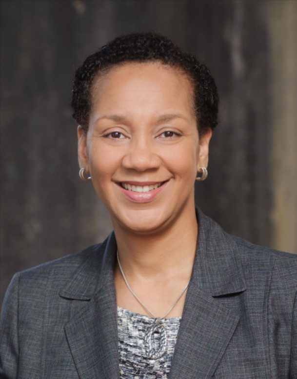 Sheri Myricks looking at you smiling grey suit jacket. .