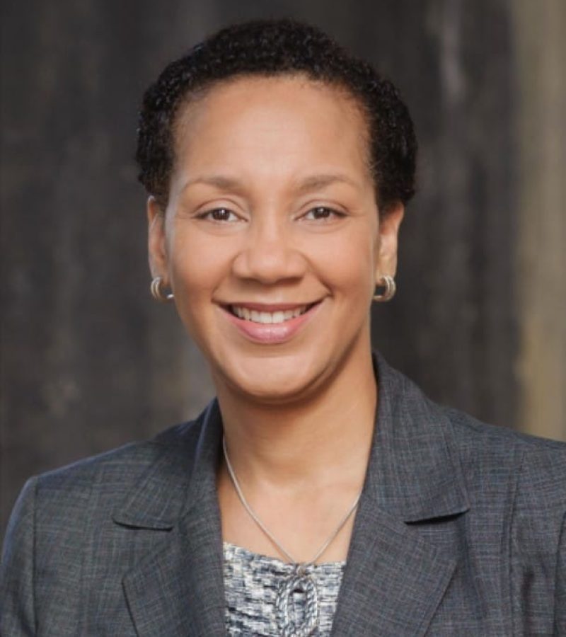 Sheri Myricks looking at you smiling grey suit jacket. .