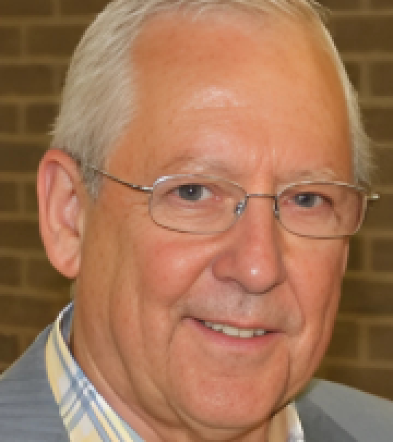 Ren Baldwin man looking at camera with a grey suit jacket and yellow blue plaid shirt under it.